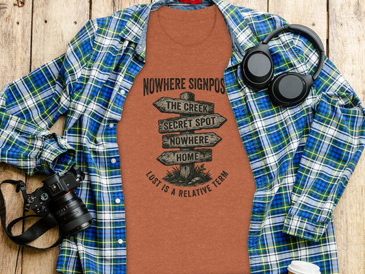 Nowhere Signpost Adventure: Backcountry Outpost Shirt: T-shirt with signpost reading "Nowhere", "Secret Spot", "Nowhere", "Home" on wooden background.