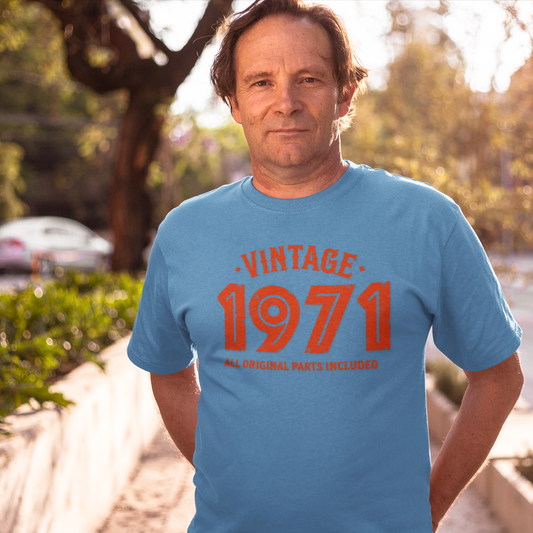 Man wearing a blue t-shirt with 'Vintage 1971' text outdoors.