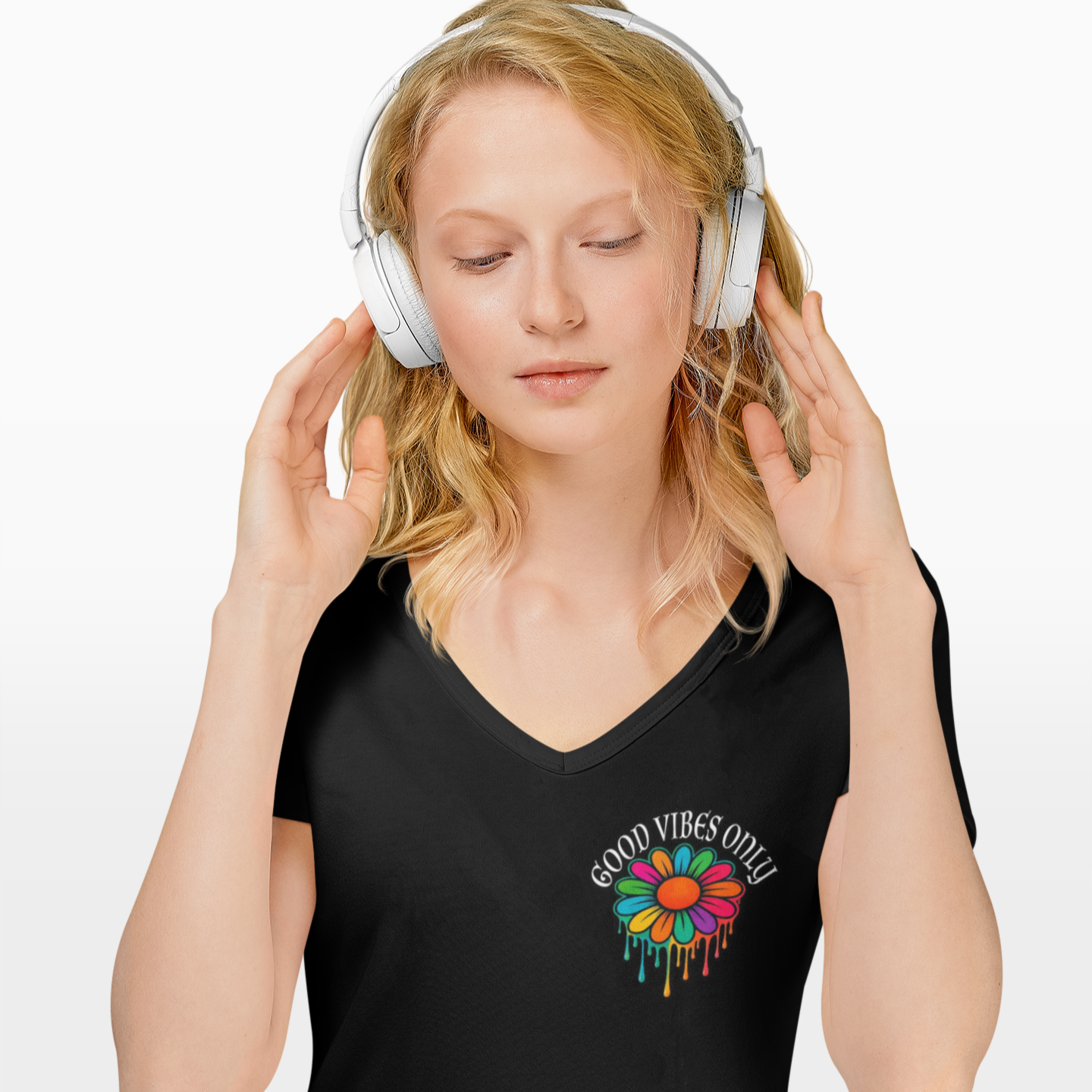 Woman wearing headphones and a black t-shirt with a colorful flower design and 'Good Vibes Only' text.
