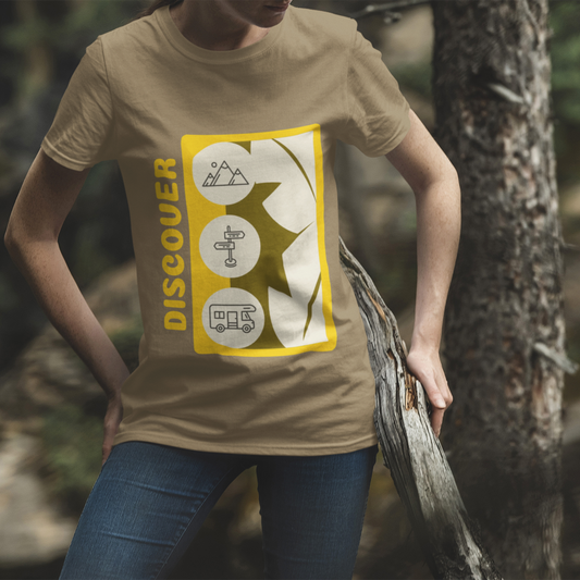 Person wearing a beige t-shirt with a yellow and white graphic design in a forest setting