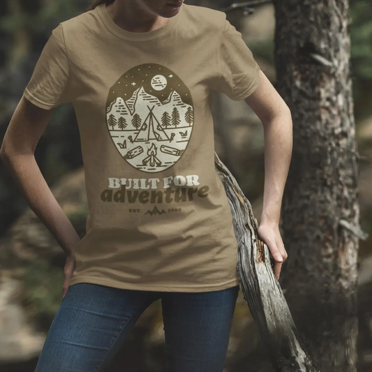 Person wearing a beige t-shirt with a nature-themed design and text, standing outdoors.