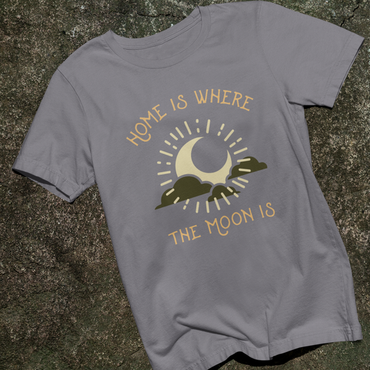 Gray t-shirt with moon and mountain graphic and text 'Home is where the moon is' on a stone surface