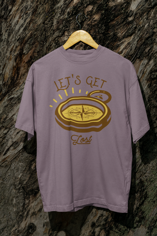 Purple t-shirt with compass graphic and 'Let's Get Lost' text on a textured stone wall background