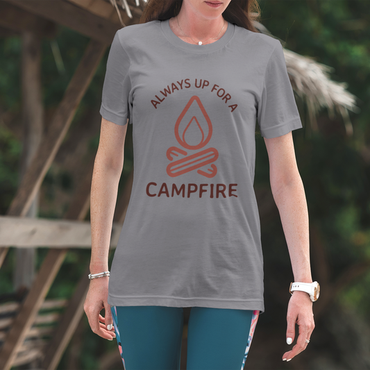 Person wearing a gray t-shirt with a campfire design and text, standing outdoors.