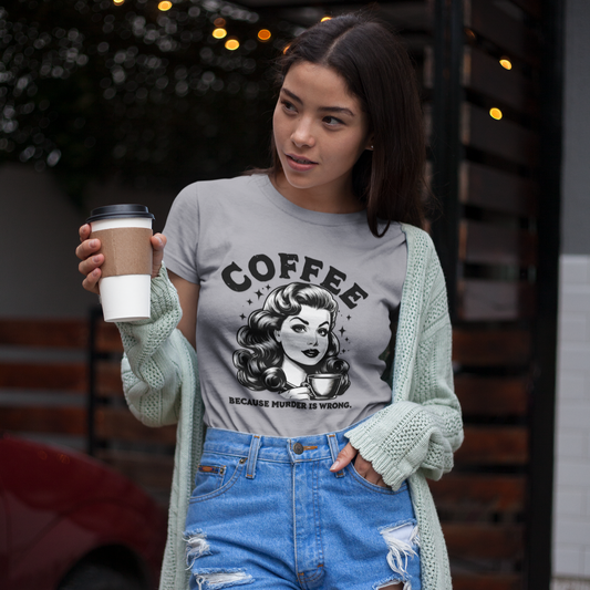 Woman holding a coffee cup wearing a graphic t-shirt with a coffee-themed design.