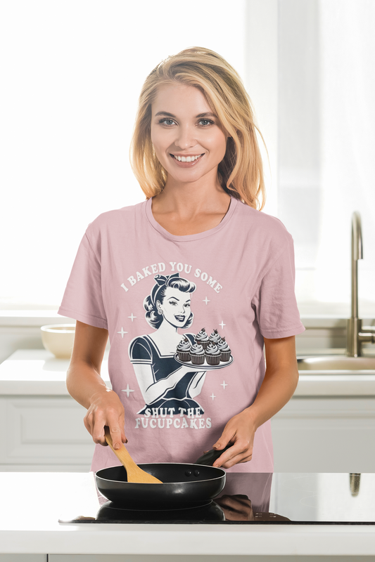 Woman wearing a pink t-shirt with a graphic design in a kitchen.