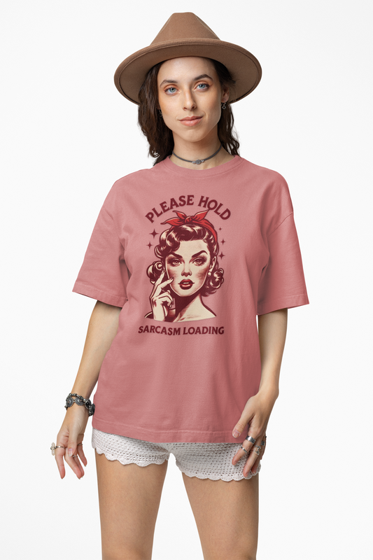 Woman wearing a pink t-shirt with a graphic design and text, standing against a white background