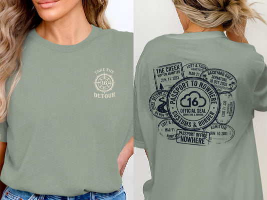 Sage green t-shirt with "Take the Detour" on front and passport stamps on back.