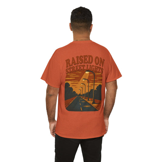 Person wearing an orange t-shirt with a graphic design and text on the back, on a white background