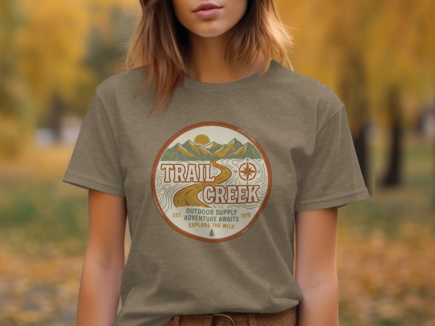Heritage Heritage Explorer Trail Creek Nomad Tee: Brown t-shirt with "Trail Creek Outdoor Supply Adventure Awaits" circular logo.