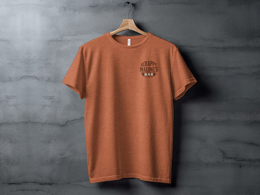 Orange t-shirt with "Scrappy Malone's Bar" logo hanging on a wall.