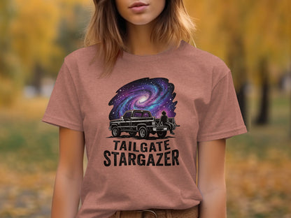 Heritage Cosmic Tailgate Stargazer Nomad Tee: T-shirt with black truck, person, and galaxy above text "TAILGATE STARGAZER".