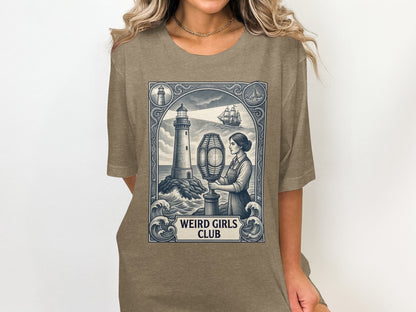 T-shirt featuring a lighthouse, ship, and woman, with "WEIRD GIRLS CLUB" text.