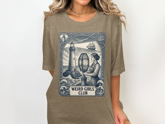 T-shirt featuring a lighthouse, ship, and woman, with "WEIRD GIRLS CLUB" text.