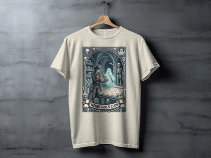 T-shirt with a "Weird Girls Club" design featuring a skeleton and a figure examining a map.
