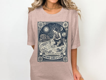 T-shirt graphic of a person working with a celestial map, "Weird Girls Club" text.