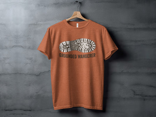 Grounded Wanderer Boot Print | Vintage Outdoor Apparel: Orange t-shirt with a black boot print graphic and "GROUNDED WANDERER" text.