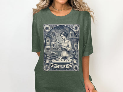 Woman in dark green t-shirt with "Weird Girls Club" graphic featuring a woman examining spiders.