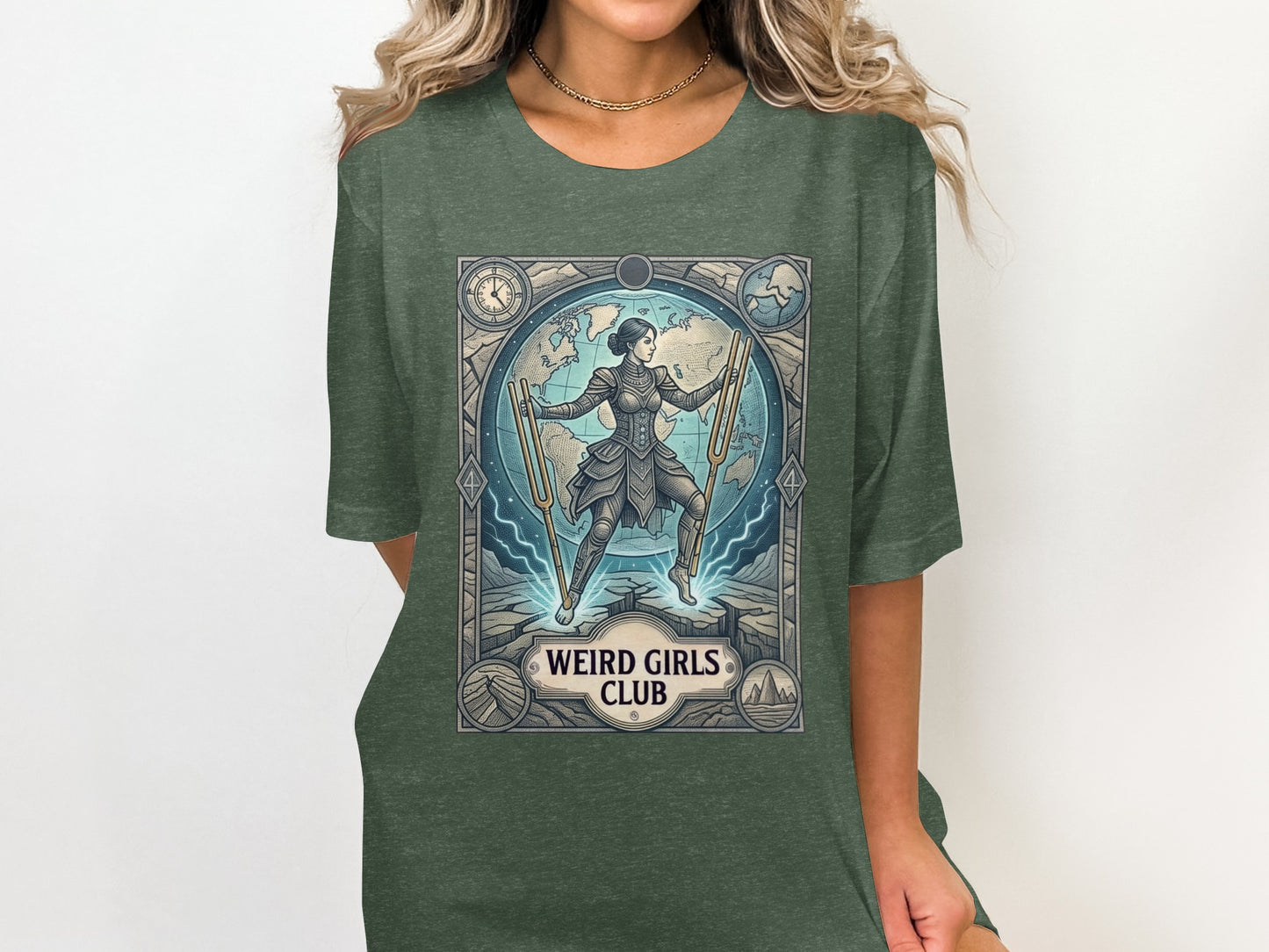 Woman wearing dark green t-shirt with a framed graphic of a woman with tuning forks.