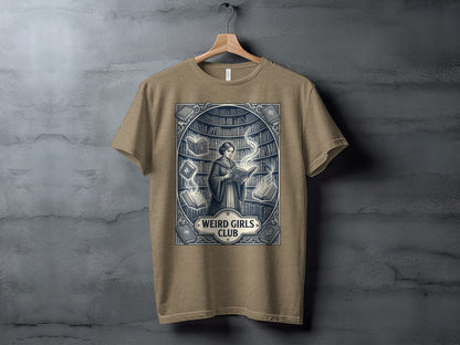 T-shirt graphic: Woman reading in a library with "Weird Girls Club" emblem.