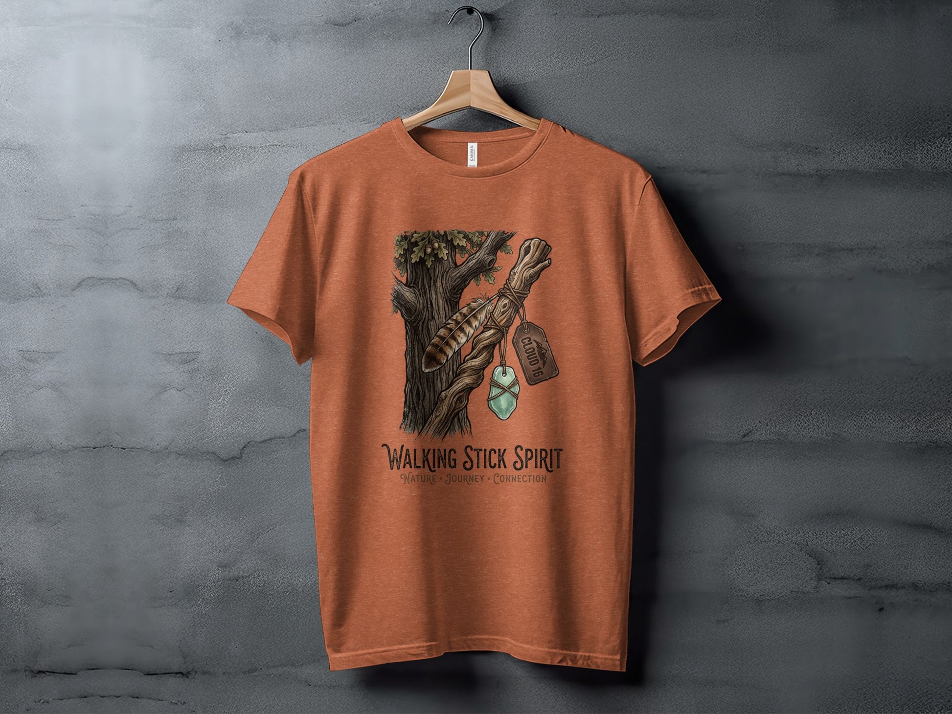 Heritage Walking Stick Spirit: Journey Nomad Tee: Orange t-shirt with a woodland nature graphic and text.