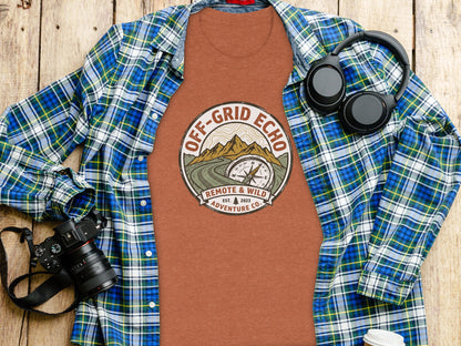 Off-Grid Echo Explorer: The Explorer's Adventure Tee: Orange t-shirt with Off-Grid Echo logo, surrounded by plaid shirt and headphones.