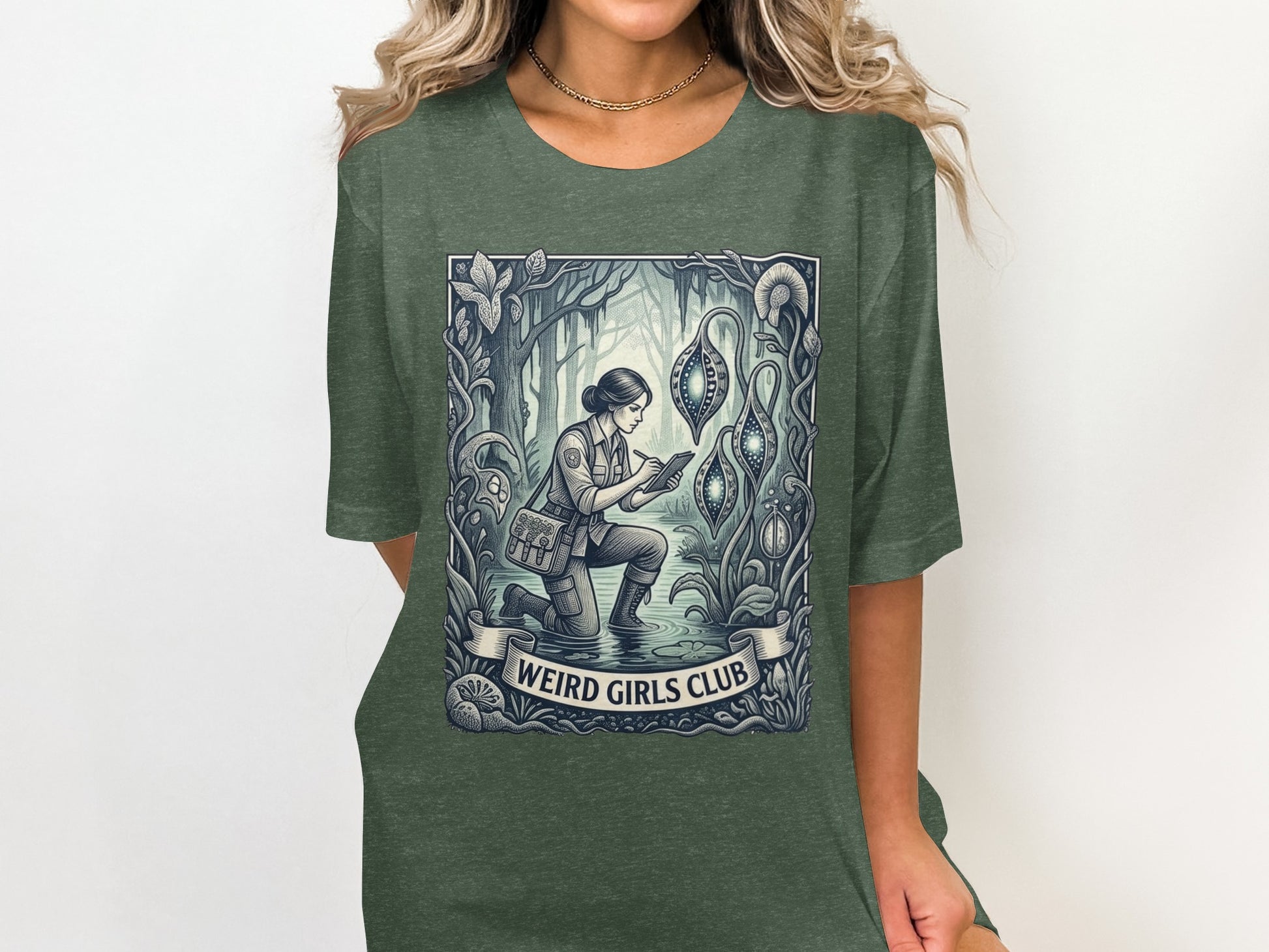 T-shirt graphic of a woman in a forest, examining glowing pods, with "Weird Girls Club" text.