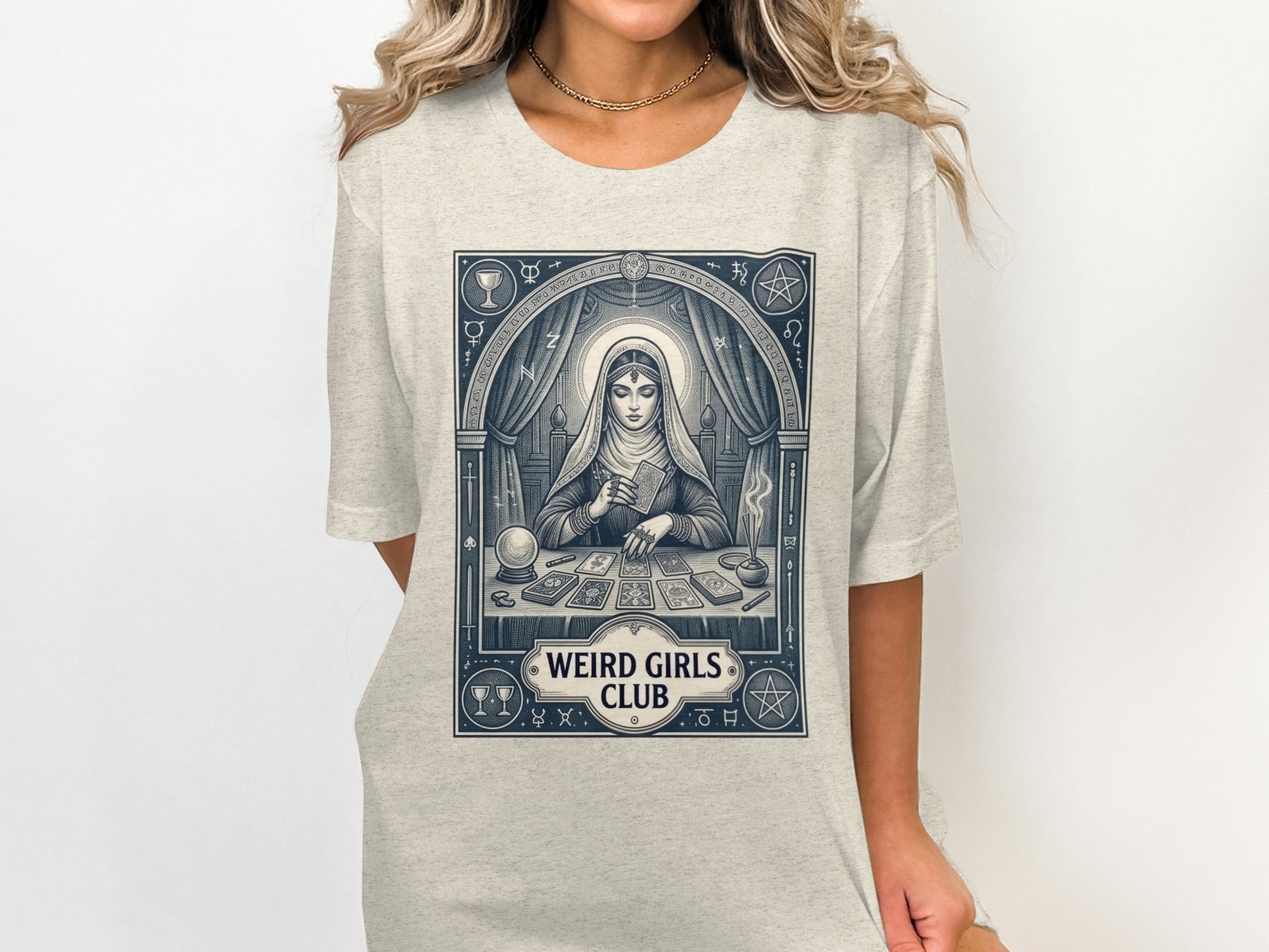 Woman wearing a t-shirt with a tarot reader illustration and "Weird Girls Club" text.
