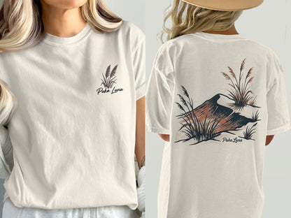 Cream t-shirt with Puka Luna logo featuring dry grass and a bird illustration.