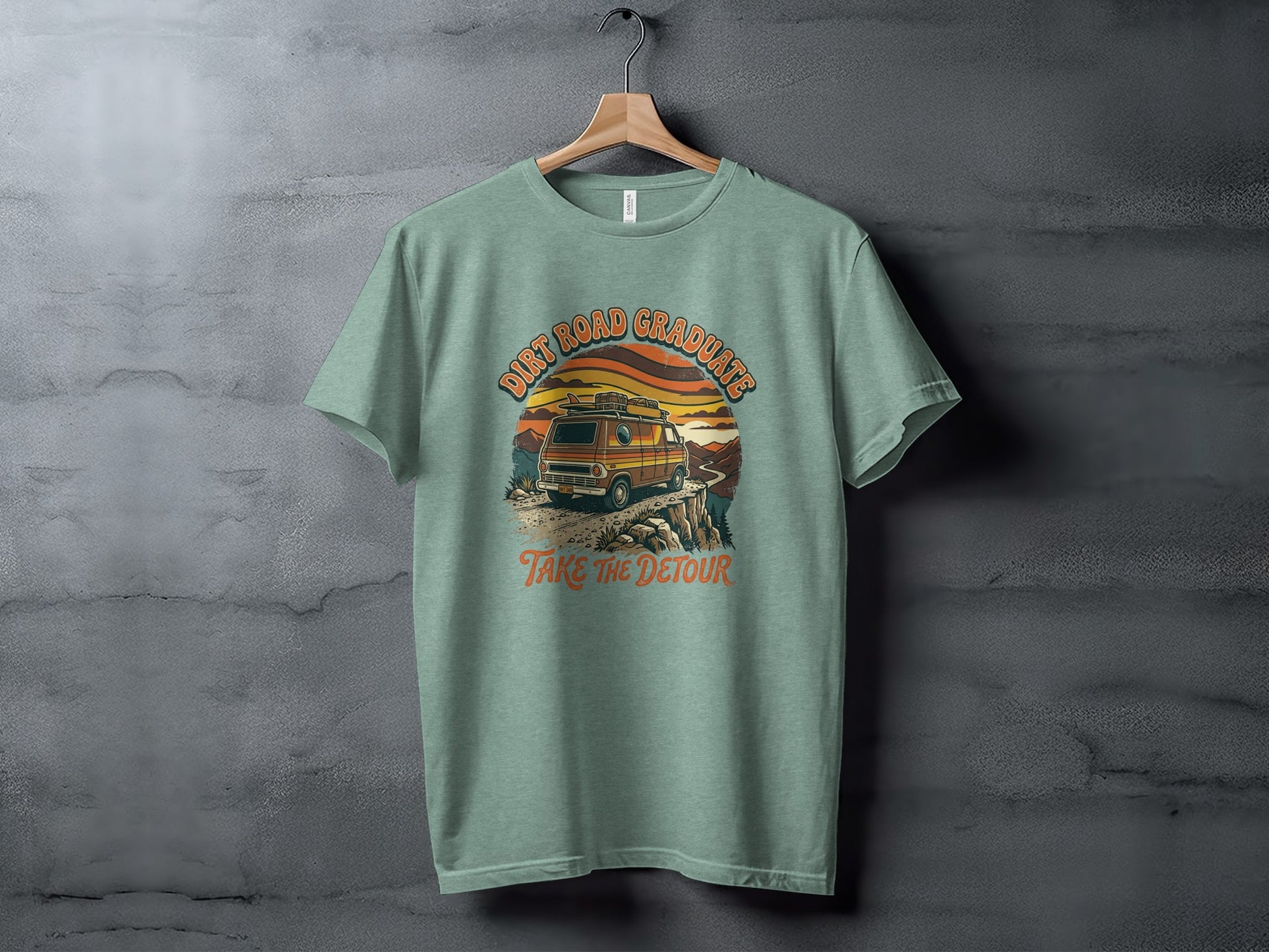 Heritage Dirt Road Graduate Adventure Tee Nomad Tee: T-shirt with a vintage van on a cliffside, "Dirt Road Graduates" and "Take the Detour" text.