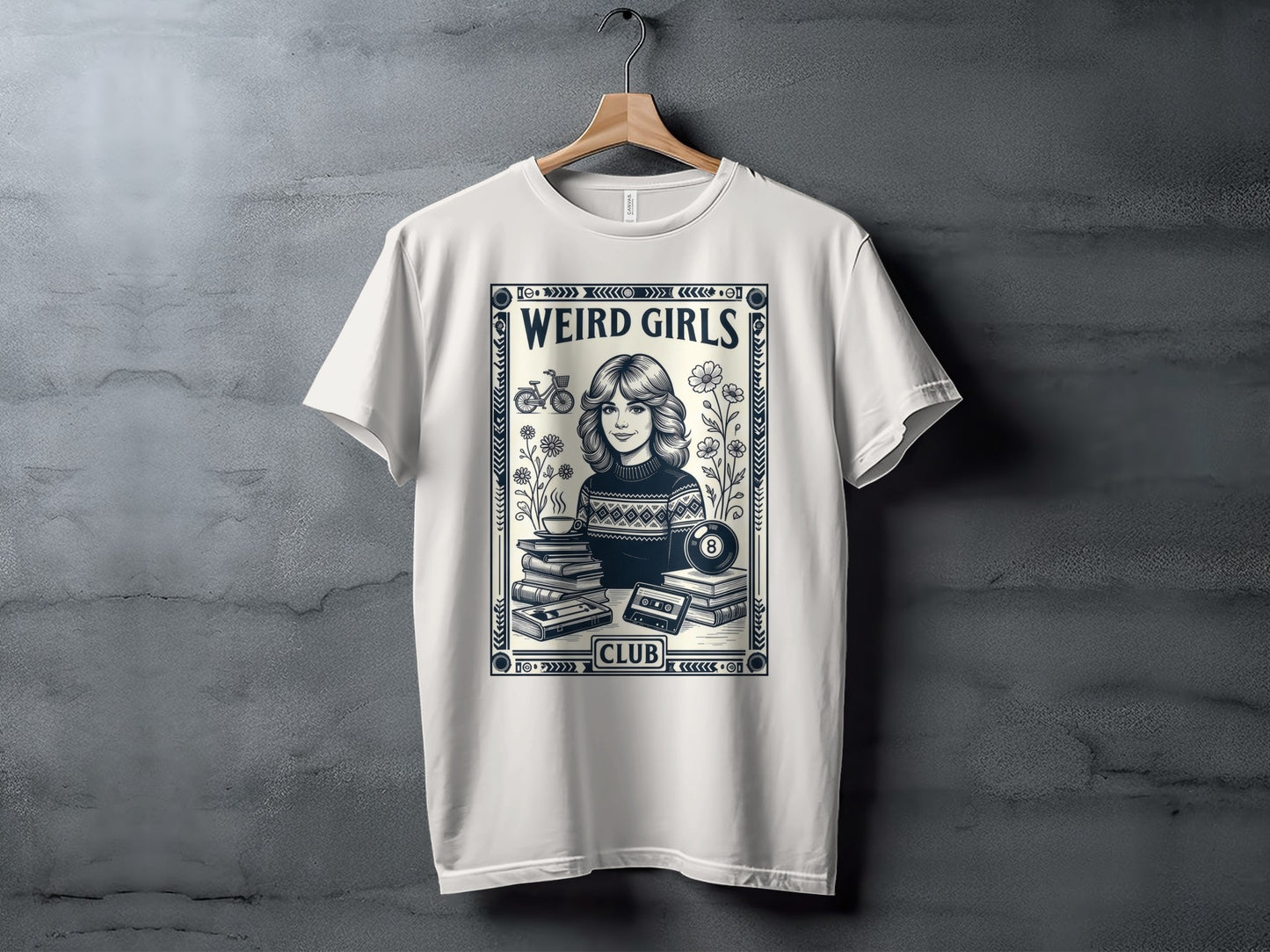 White t-shirt with "Weird Girls Club" text, retro cassette, books, flowers, and billiard ball.