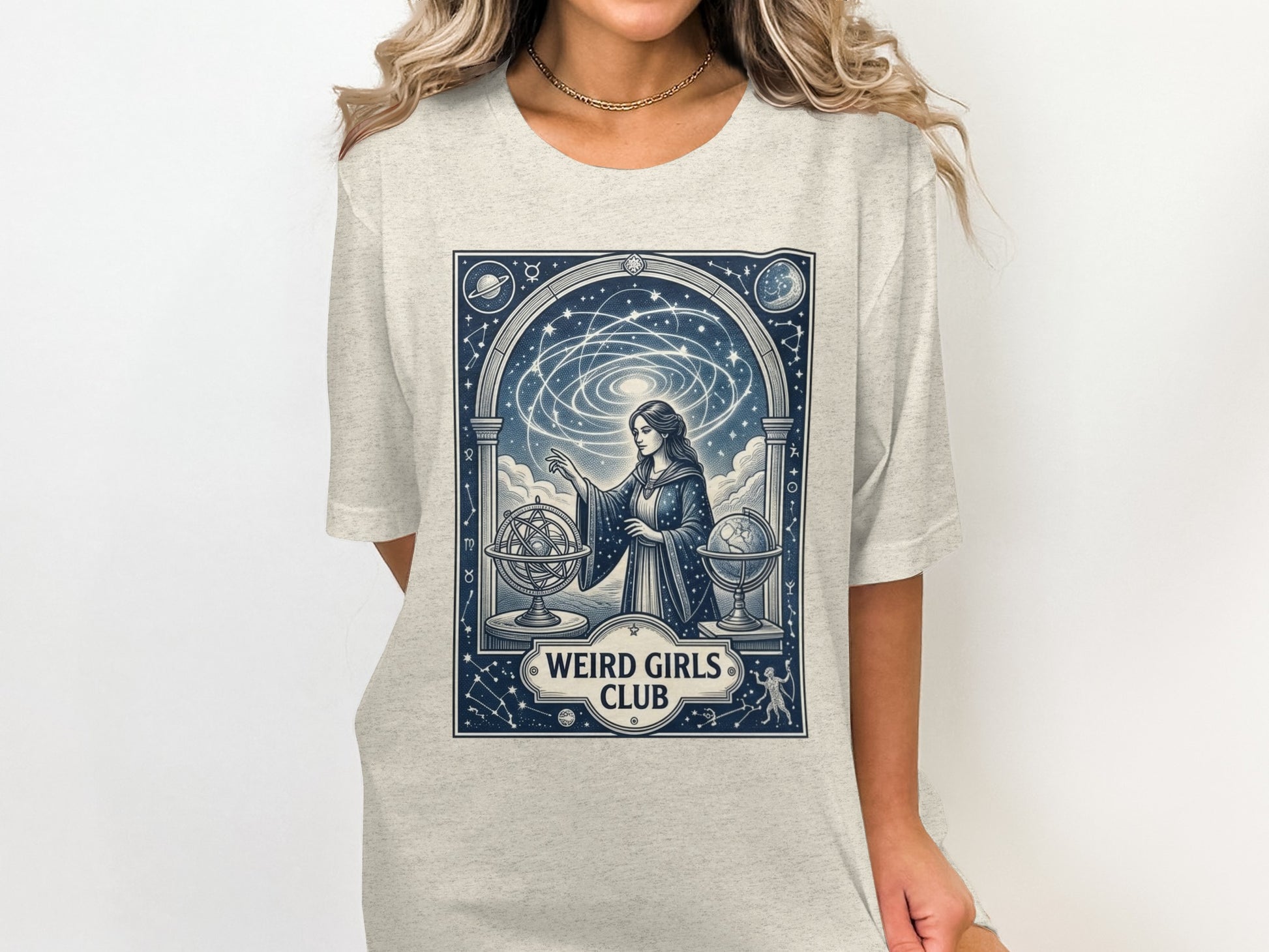 T-shirt graphic: woman with celestial globe and constellations, "Weird Girls Club."