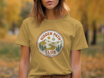 Rugged Hidden Path Club Explorer Wilderness Shirt: Mustard t-shirt with "Hidden Path Club Explore & Discover" circular logo featuring mountains.