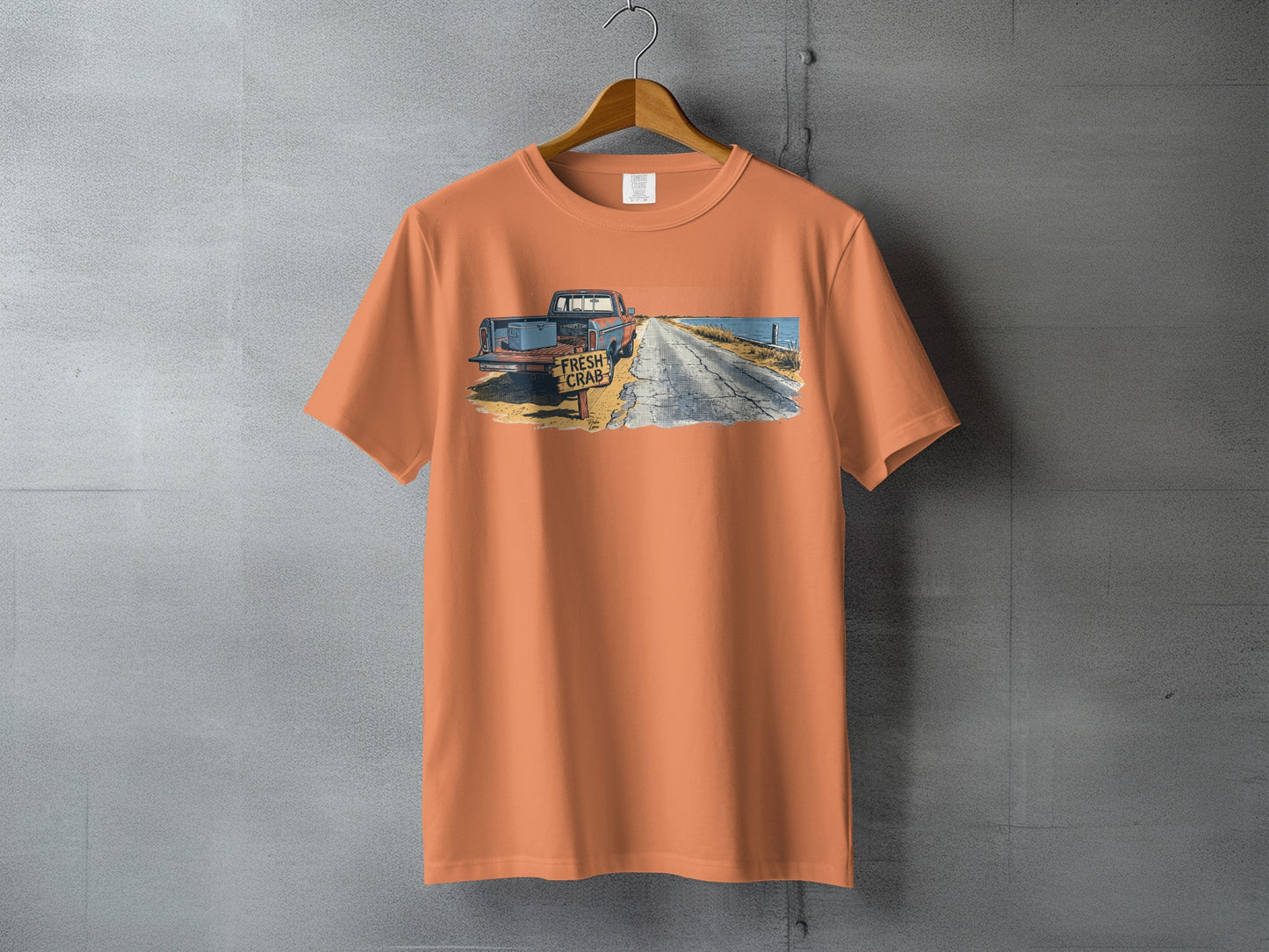 Orange t-shirt with graphic of a vintage truck and "Fresh Crab" sign.