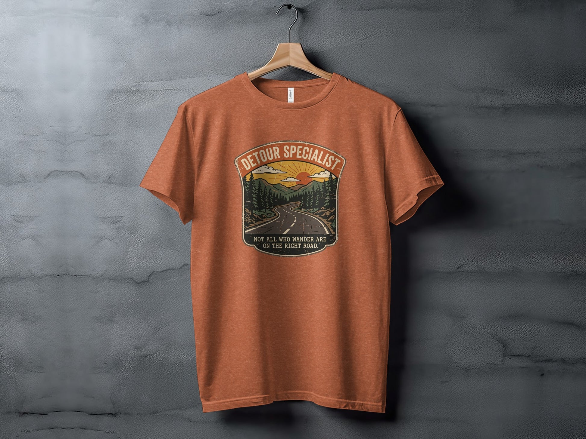 Heritage Detour Specialist Vintage Graphic Nomad Tee: Orange t-shirt with "Detour Specialist" and mountain road sunset graphic.