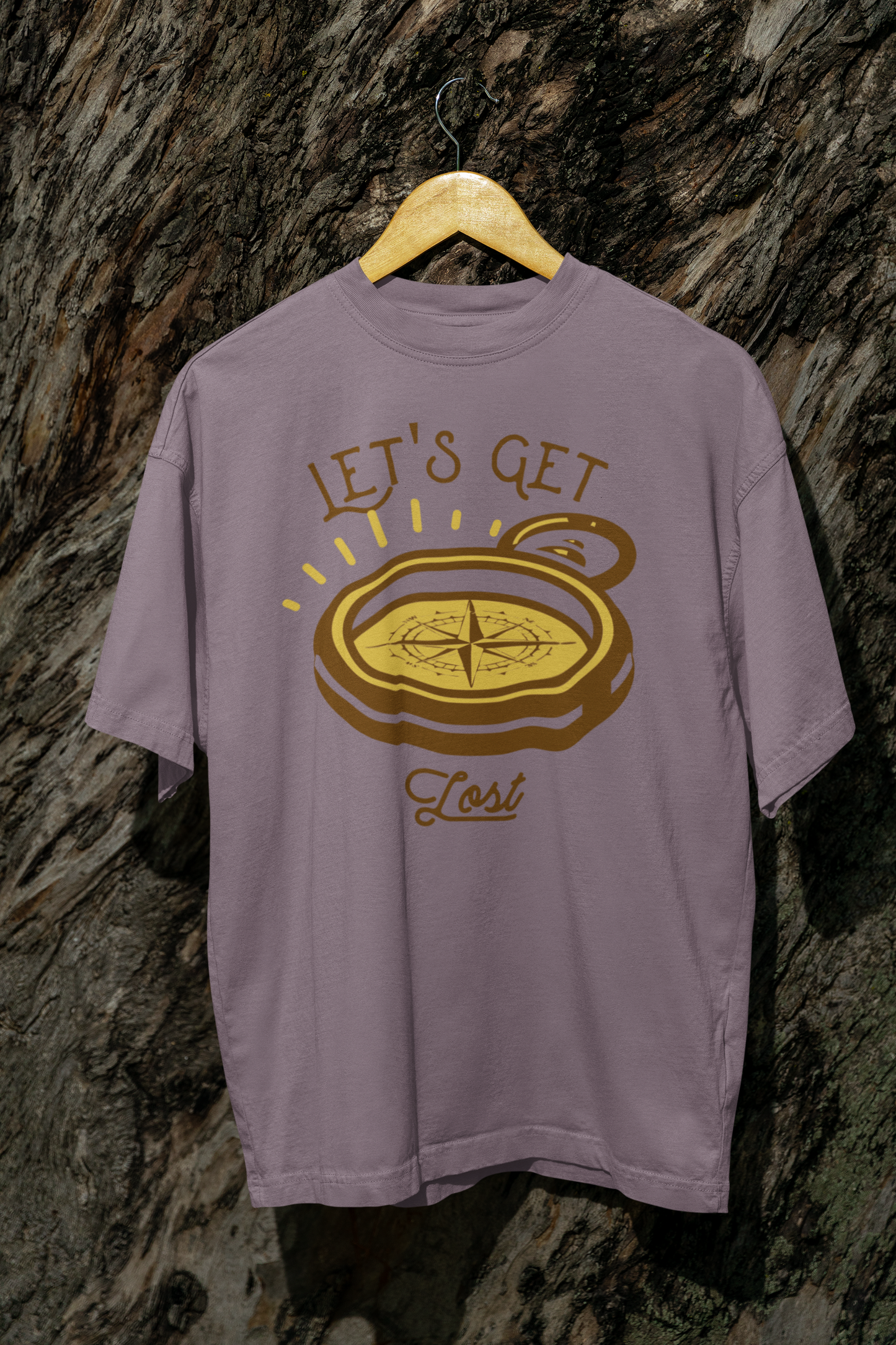 Purple t-shirt with compass graphic and 'Let's Get Lost' text on a textured stone wall background