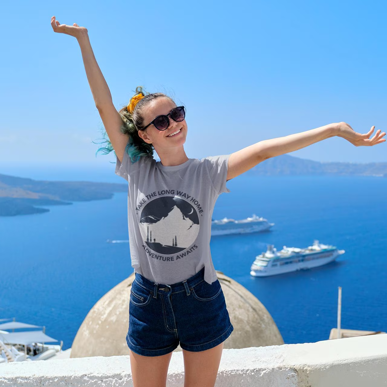Woman with arms outstretched in front of a scenic view with boats and blue sky.