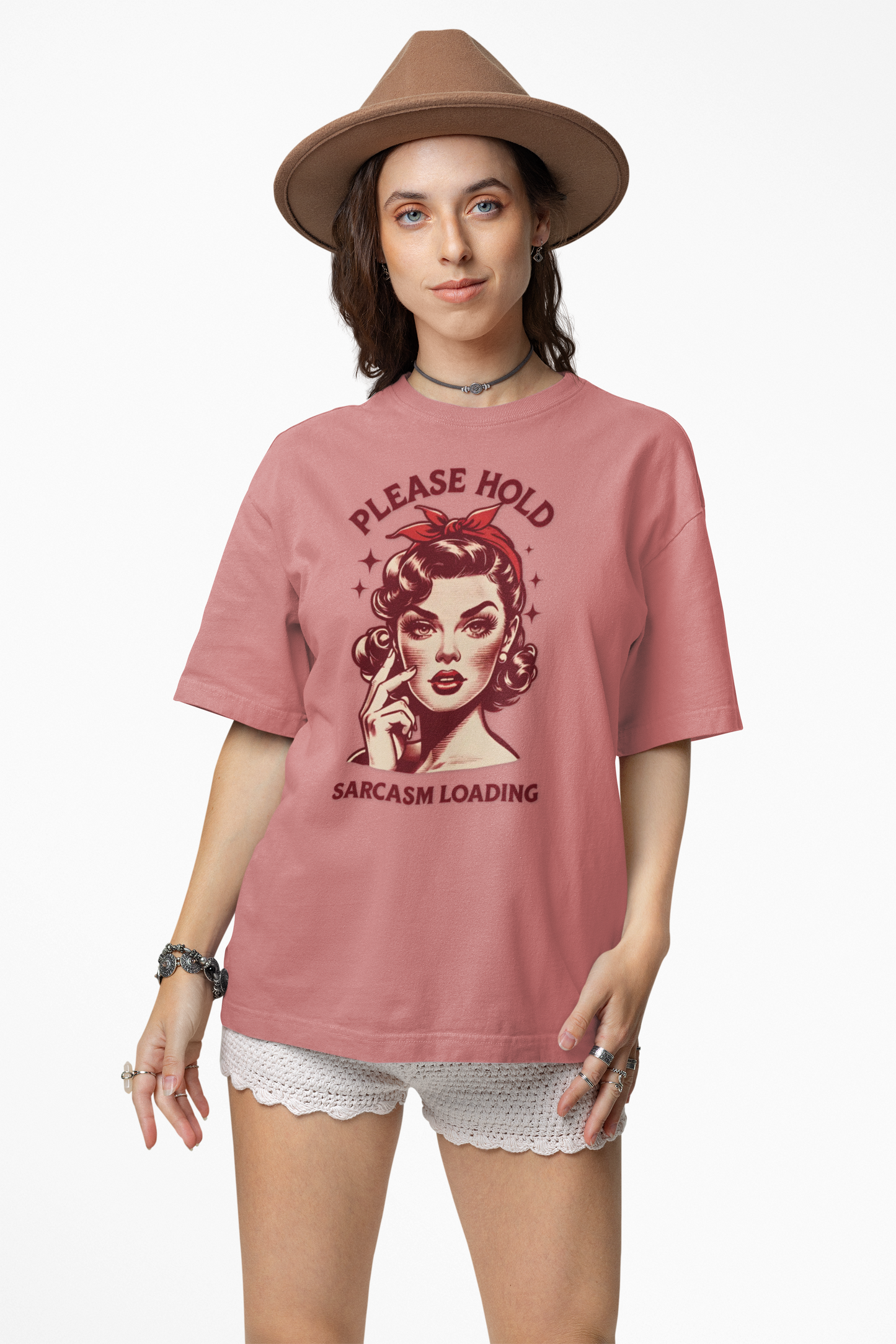Woman wearing a pink t-shirt with a graphic design and text, standing against a white background
