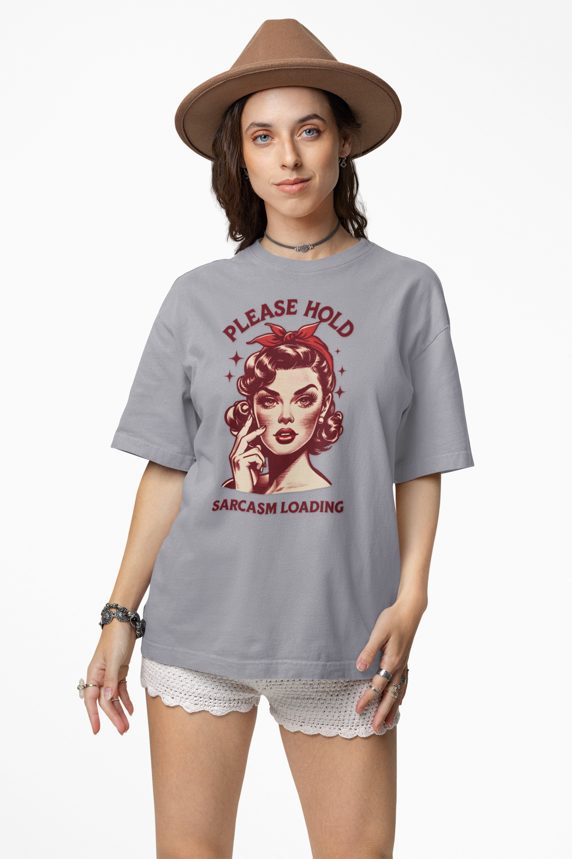 Woman wearing a gray t-shirt with a graphic design and text, standing against a white background