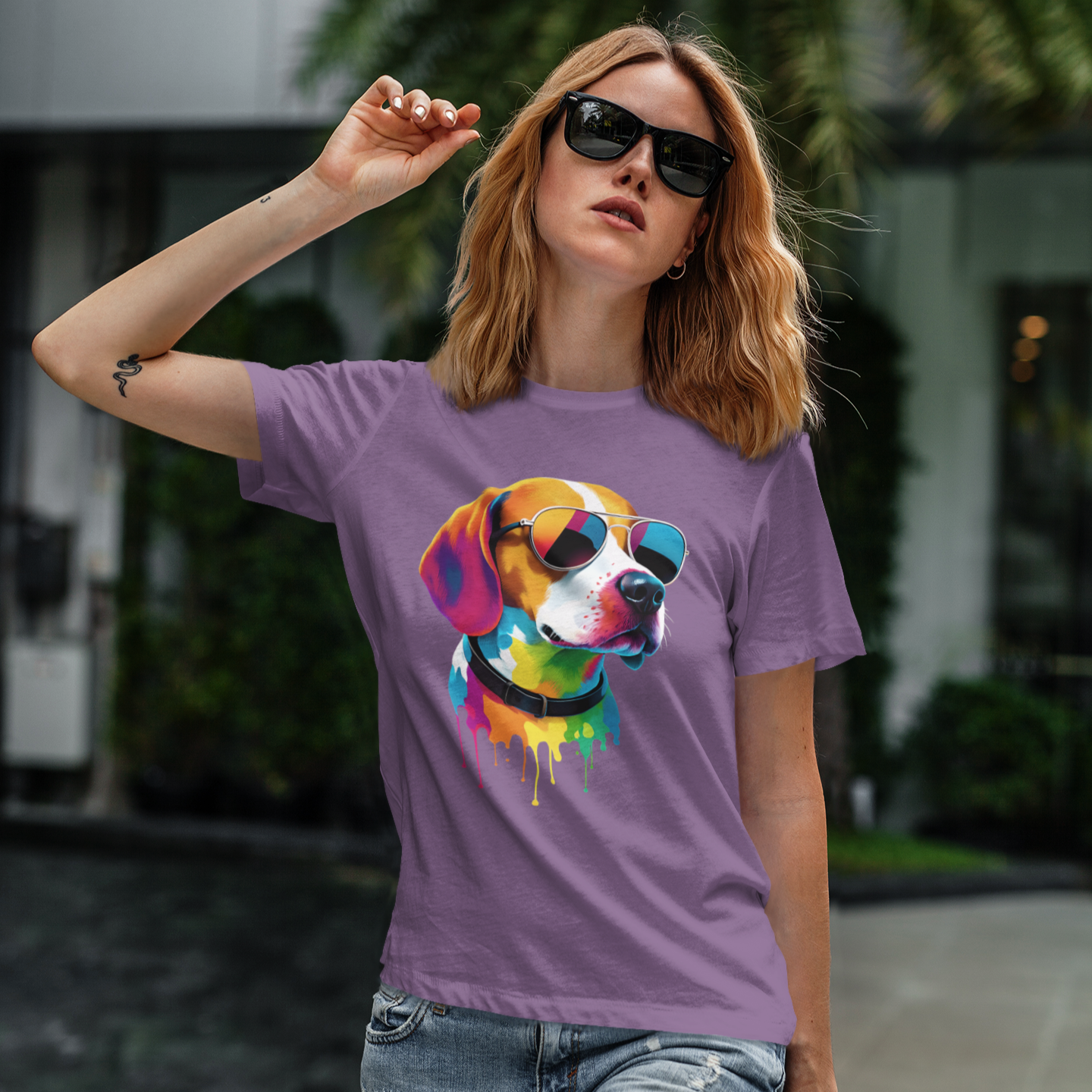 Woman wearing a purple t-shirt with a colorful dog graphic outdoors.