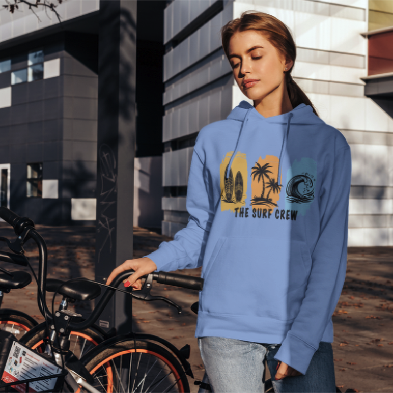 Person wearing a blue hoodie with 'The Surf Crew' design, standing next to bicycles.