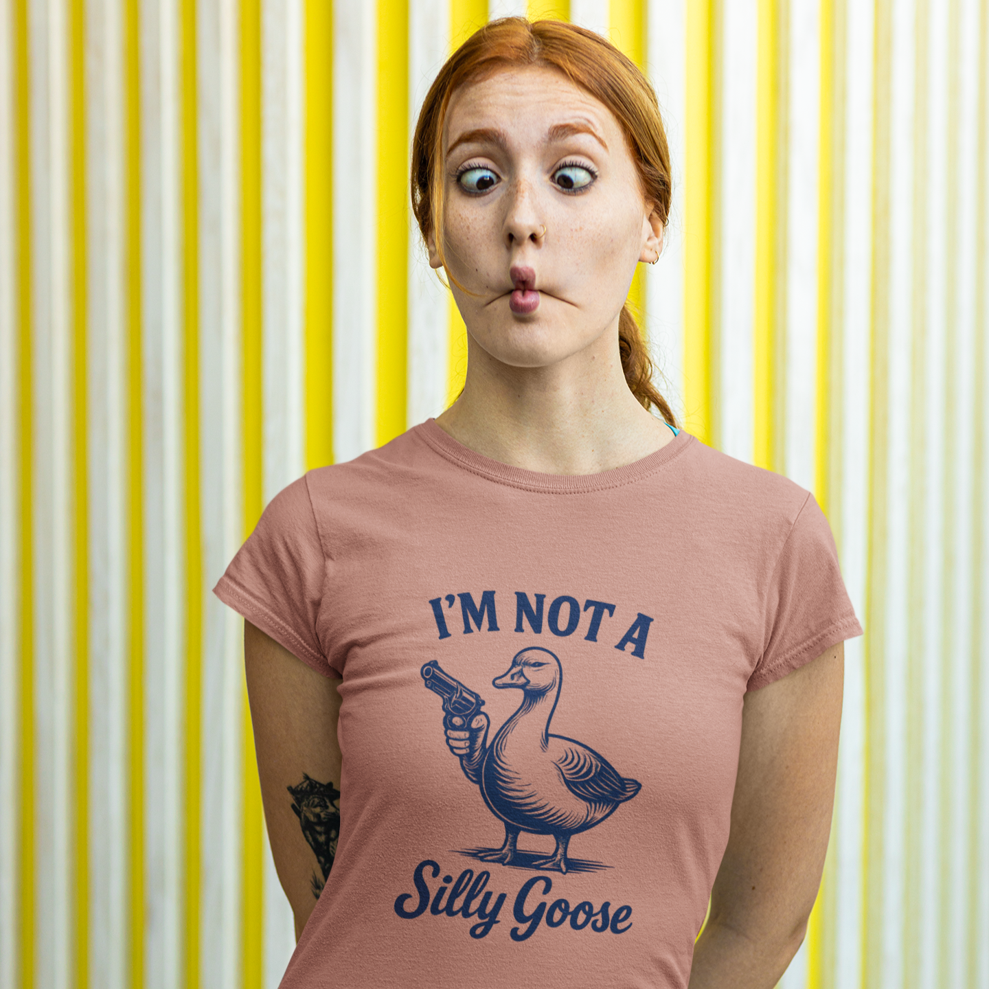 Person wearing a t-shirt with a graphic and text against a yellow and white striped background