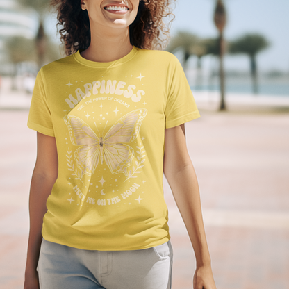 Woman wearing a yellow t-shirt with a butterfly design on a beach.