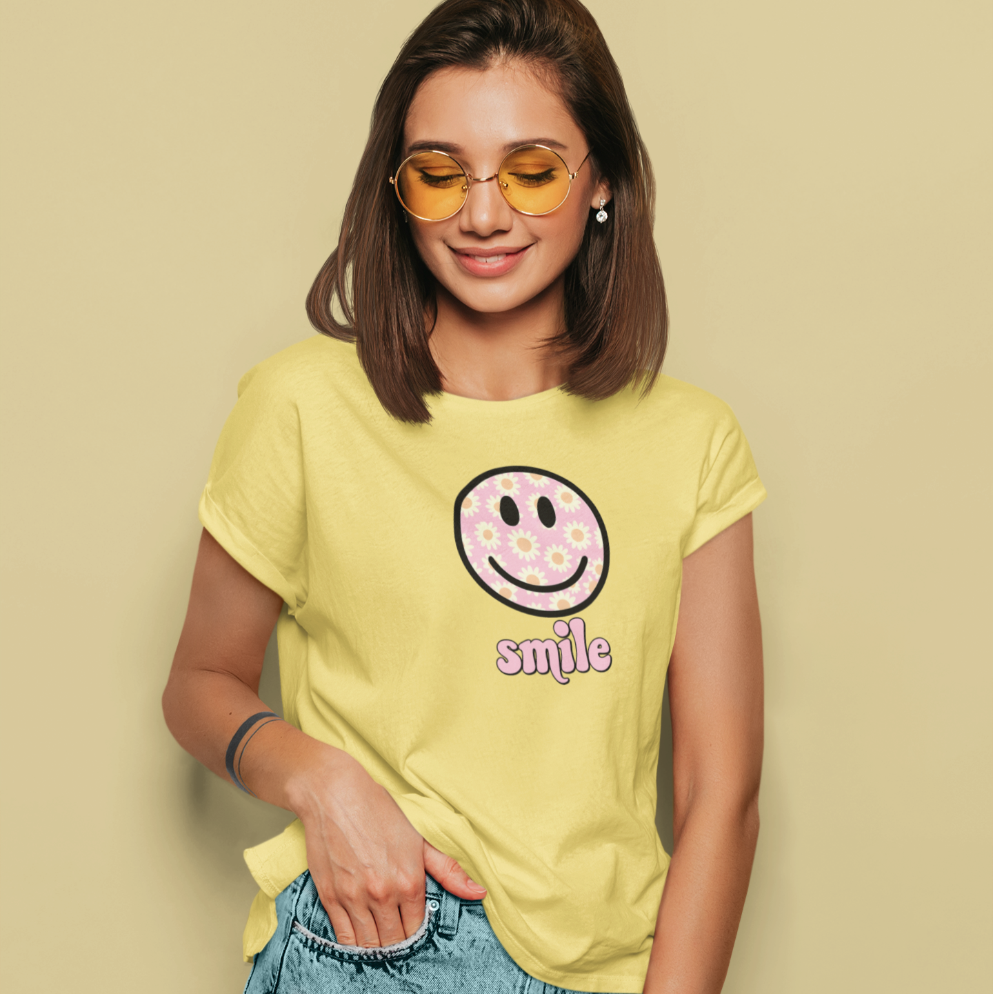 Woman wearing a yellow t-shirt with a smiley face design on a beige background