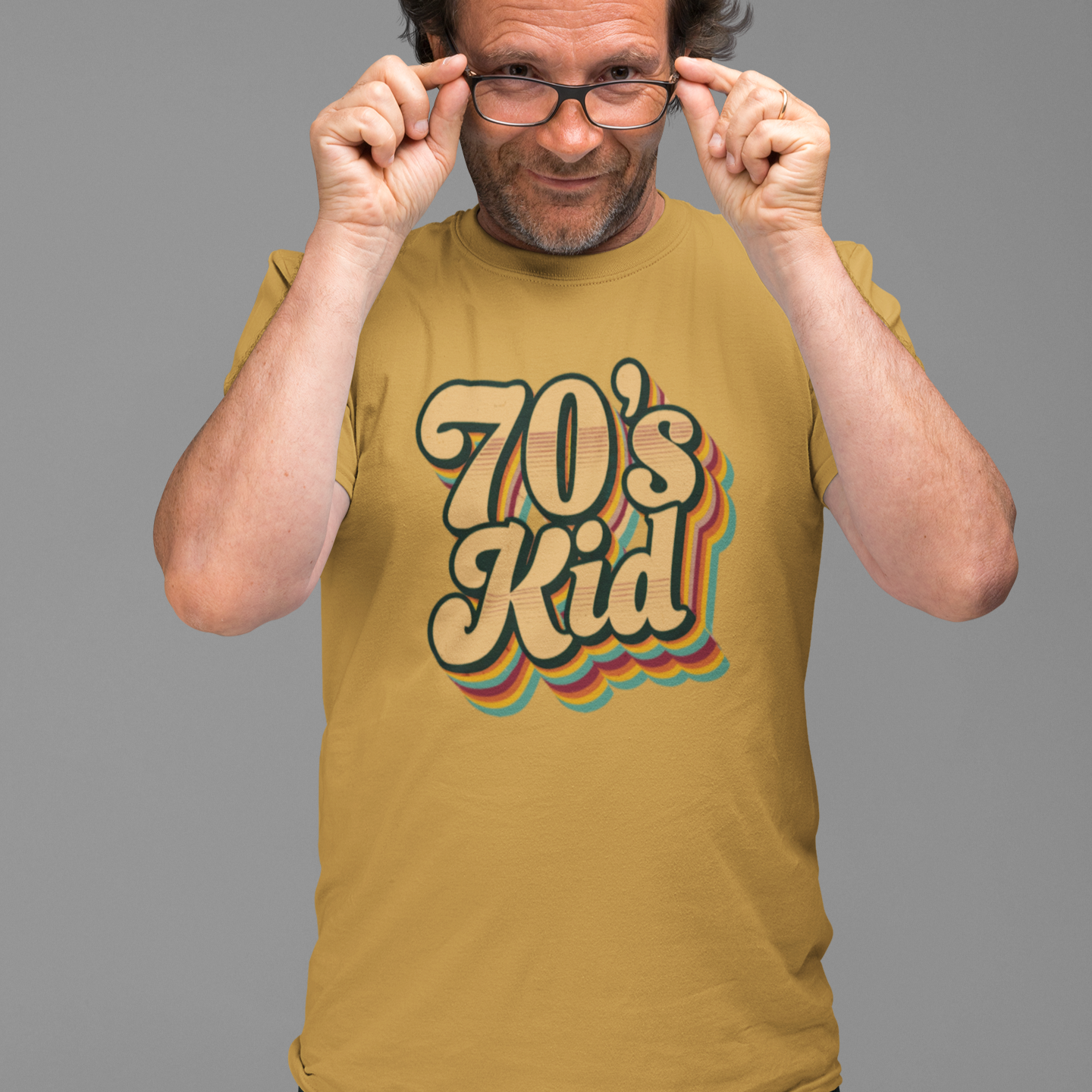 Man wearing a mustard yellow t-shirt with '70's Kid' text on a gray background