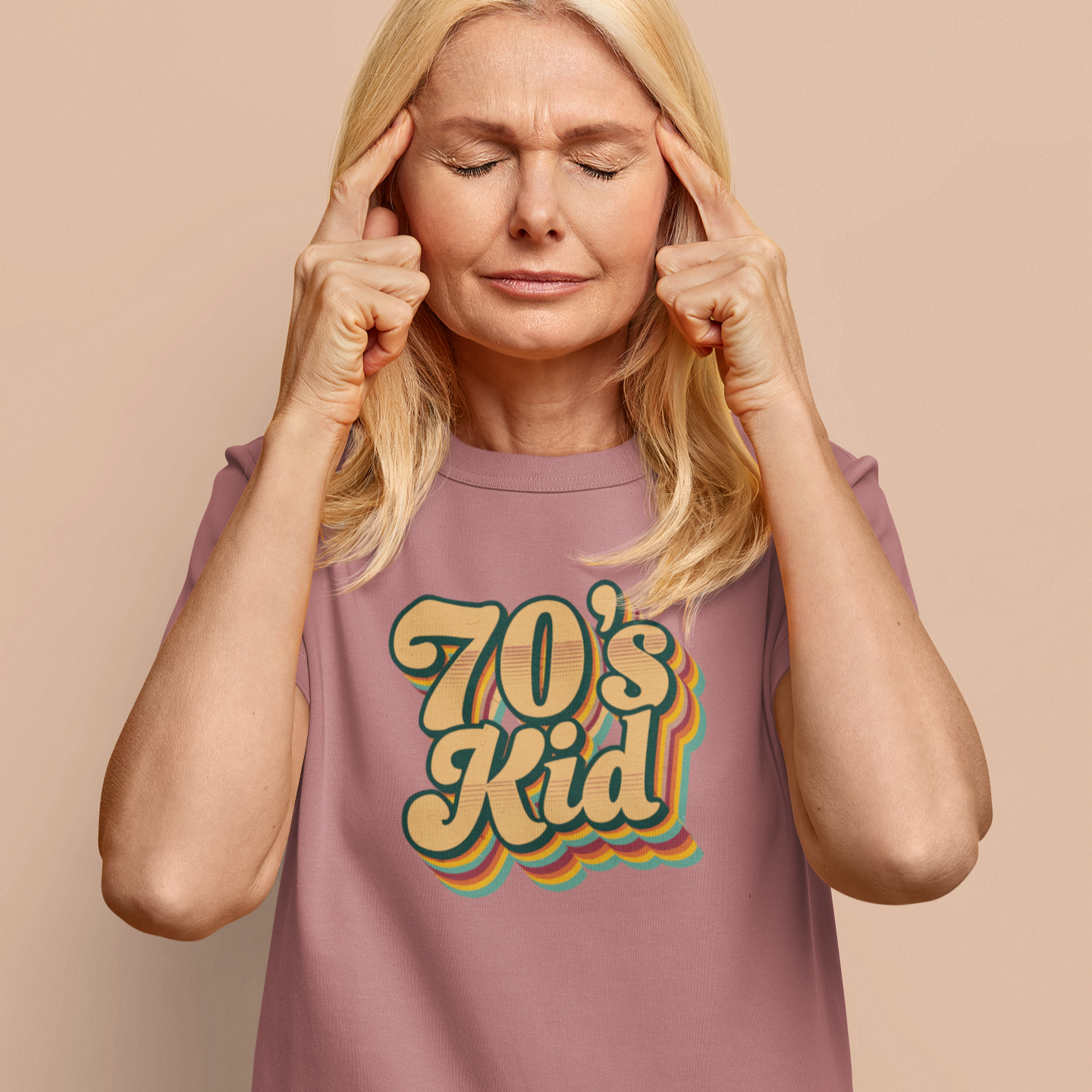 Woman wearing a '70's Kid' t-shirt against a beige background