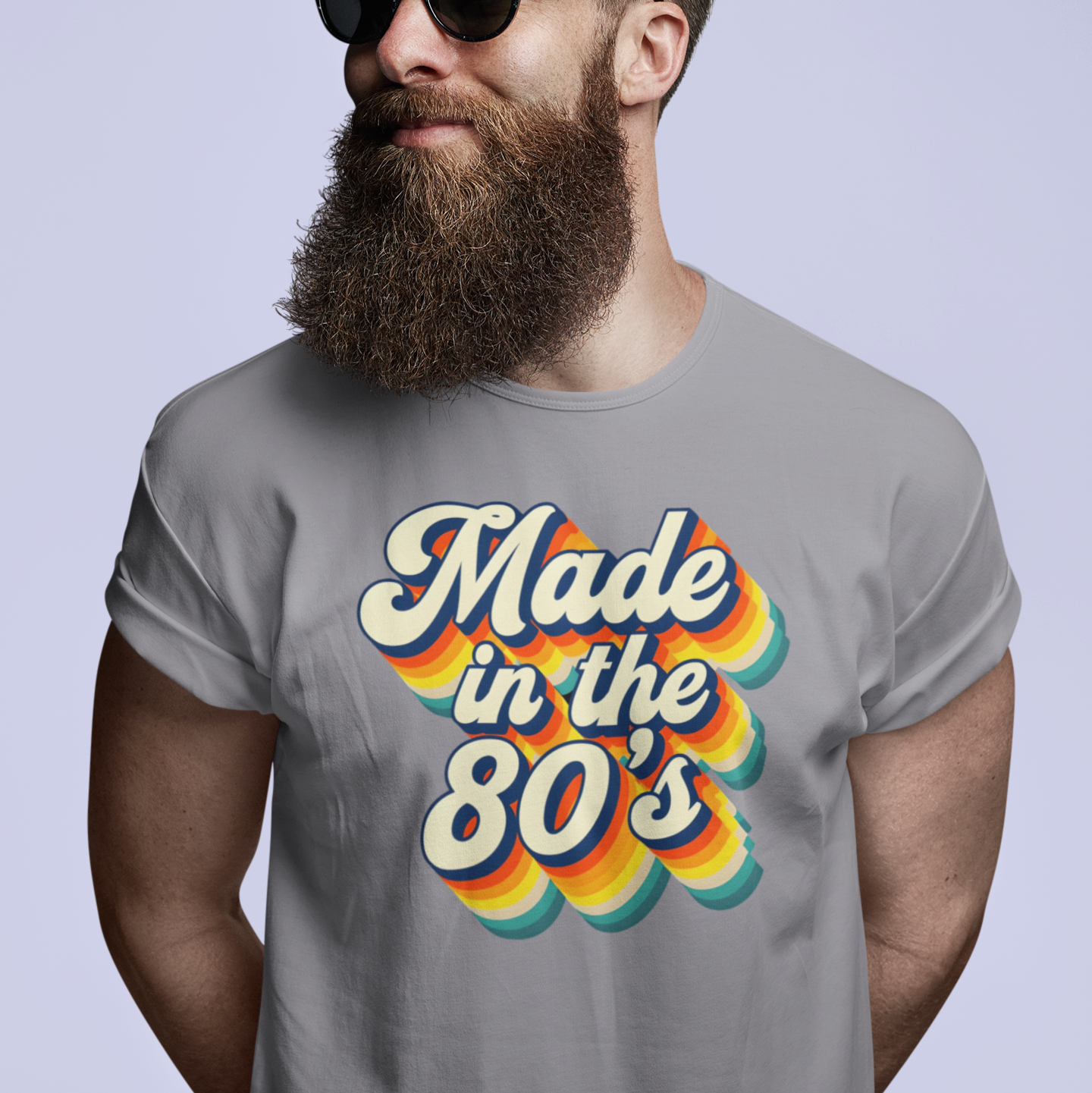 Man wearing sunglasses and a gray t-shirt with 'Made in the 80's' design on a light gray background