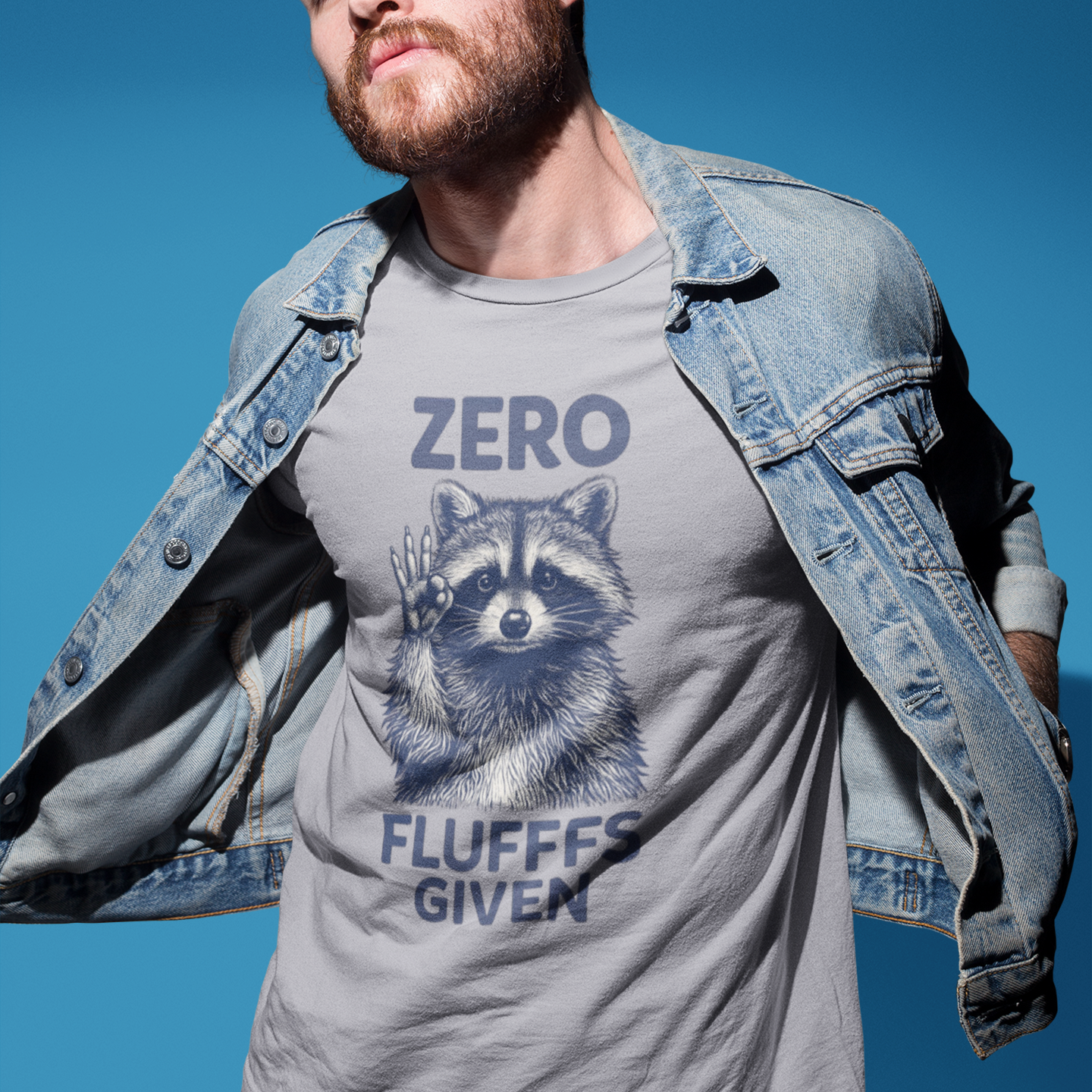 Man wearing a gray t-shirt with a raccoon graphic and text against a blue sky