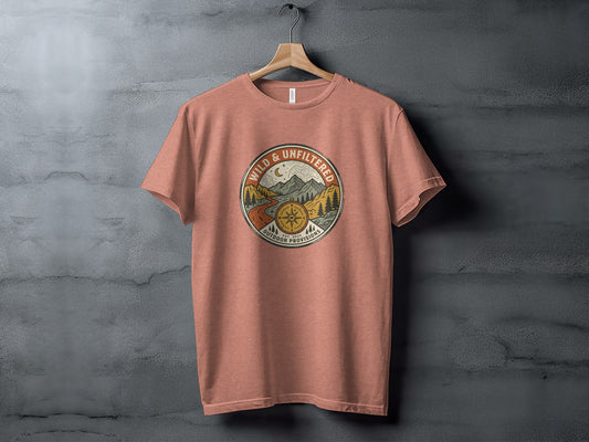 Rugged Wild & Unfiltered Explorer Wilderness Shirt: Peach t-shirt with circular outdoor scene logo featuring mountains, sun, and compass.
