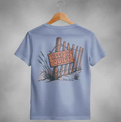 T-shirt with "KEEP IT QUIET" sign and Puka Luna logo on a wooden fence.